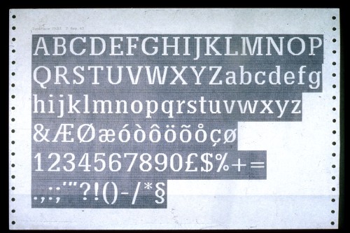 Reversed printout on tractor-feed paper shows an alphabet setting of a slabserif typeface